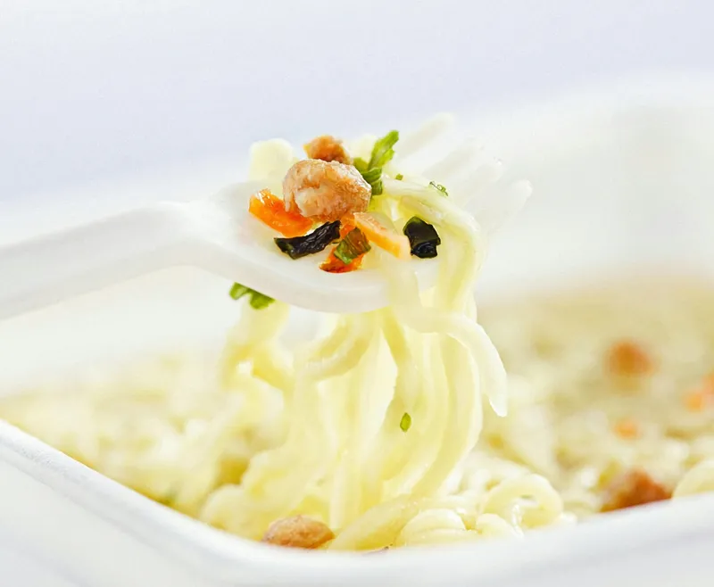 Close-up of air-dried instant noodles in hot soup showing smooth texture