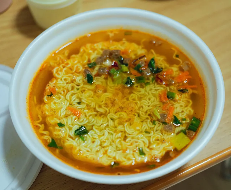 Instant noodles in bowl with soup and vegetables, ready-to-eat Asian noodle food